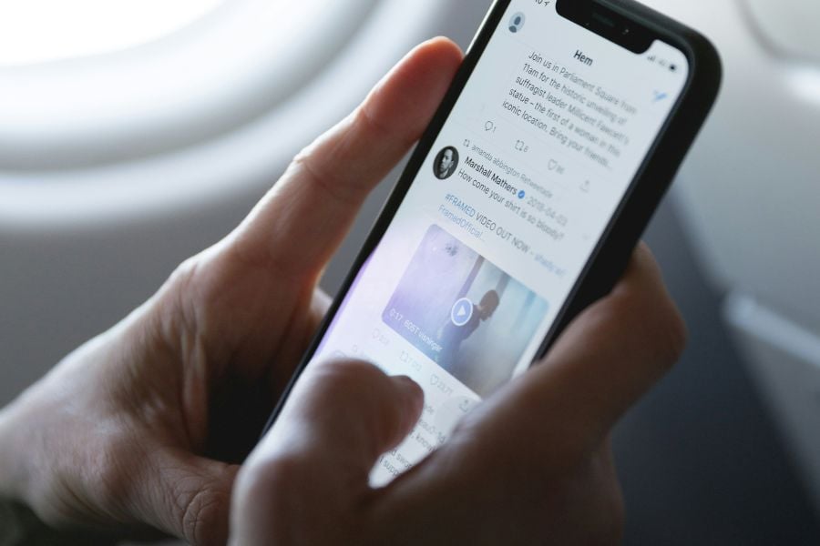 hand holding cell phone showing social media feed